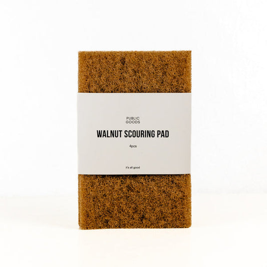 The Public Goods Walnut Scouring Pads come in a 4-pack with a white label and are made from plant-based materials—perfect for tough messes.