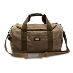 The Duck Head Waxed Canvas Overnighter Bag in Field Brown features olive green straps, a front pocket, brass hardware, and a detachable shoulder strap—ideal as a travel bag, shown against a white background.