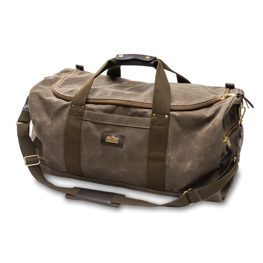 The Duck Head Waxed Canvas Weekender Bag features brown waxed canvas, dark brown straps, a zip main compartment, exterior pocket, detachable shoulder strap, is carry-on compliant, and made in the USA.