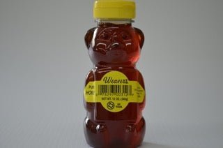 A plastic bear-shaped bottle filled with Pure Local Honey from R. Weaver Apiaries, sealed with a yellow cap and labeled "Weaver's Honey | R. Weaver Apiaries" along with product information.