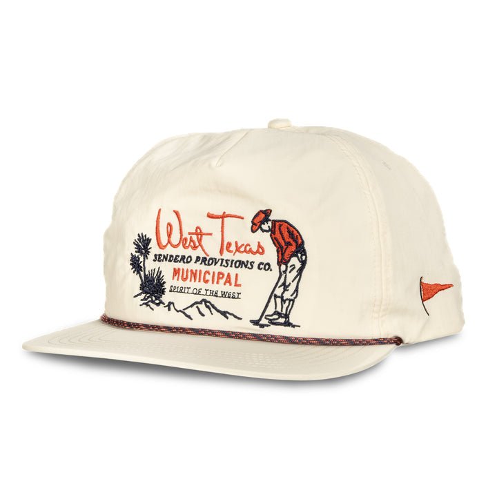 The West Texas Municipal Hat by Sendero Provisions Co. is a cream 5-panel pop-up cap with "West Texas Sendero Provisions Co.," an embroidered figure, desert scene on the front, quick-dry nylon fabric, and paracord rope detail for style.