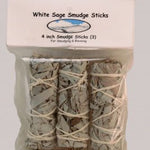 A plastic package of three 4-inch Taos Herb Co. White Sage Smudge Sticks (Salvia Apiana), wrapped with string, labeled "White Sage Smudge Stick | Taos Herb Co."—perfect for smudging and blessing.