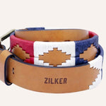 The Willie | Zilker Belt by Zilker Belts is crafted from Argentine leather, featuring "ZILKER" embossing and a vibrant hand-stitched geometric pattern in red, white, and blue.