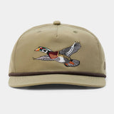 The Wood Duck Hat by Duck Camp features a khaki snapback design with an embroidered flying wood duck on the front, dark brown trim above the brim, and an adjustable snapback closure for a perfect fit.