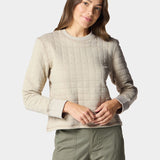 A person wearing the Duck Camp W's Cheyenne Quilted Crew in light beige and olive green pants stands against a plain light background.