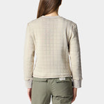 A person with long brown hair faces away, wearing the Duck Camp W's Cheyenne Quilted Crew and olive green pants—this quilted cotton crew neck sweater from Duck Camp is a comfy mid-layer ideal for everyday layering.