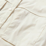 Close-up of the Duck Camp W's Lightweight Fishing Shirt Long Sleeve in light beige, featuring a chest pocket and a subtle embroidered logo above it.