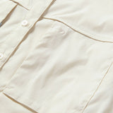 Close-up of the Duck Camp W's Lightweight Fishing Shirt Long Sleeve in light beige, featuring a chest pocket and a subtle embroidered logo above it.