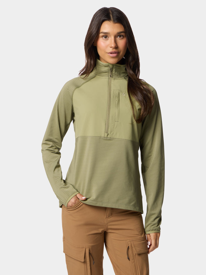 A woman stands facing forward, wearing the Duck Camp W's Lightweight Grid Tech Fleece Half Zip in Sagebrush and tan cargo pants, with one hand in her pocket against a plain background.