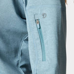 Close-up of the Duck Camp W's Rockport Hoodie in Heathered Trooper, showing a light blue sleeve with a small vertical zippered pocket and visible stitching, made from cooling material for comfort.