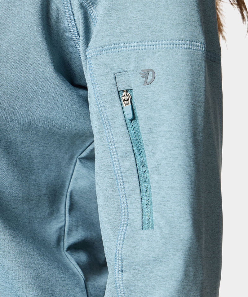 Close-up of the Duck Camp W's Rockport Hoodie Heathered Trooper in light blue, highlighting its lightweight sleeve with a small zippered pocket and visible stitching details.