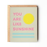 The "You Are My Sunshine" card by Daydream Prints features pink text, a yellow sun, and two blue lines on A2 size. Comes with a recycled envelope. Designed in Portland, Oregon.