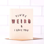 Daydream Prints’ “You’re Weird & I Love You” A2 card features pink and black text on a white tiled background, comes with a recycled envelope, and is made in Portland—perfect for celebrating quirky connections.