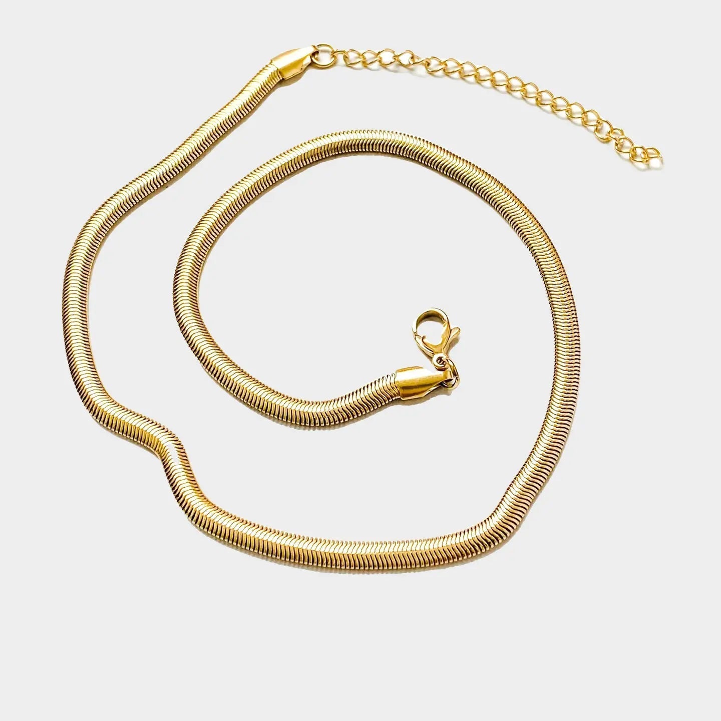 The Zoe Gold Snake Chain Necklace by Peter and June is a waterproof, gold-plated necklace with a lobster clasp and adjustable extender, shown on a white background.
