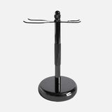 The Rockwell Razors 3-Piece Shave Stand features a metal design with a round base, central pole, and two hooks—ideal for organizing double-edge razors and brushes for wet shavers.
