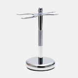 The Rockwell Razors 3-Piece Shave Stand is chrome-plated with a round base and two prongs, perfect for wet shavers to neatly hold a shaving brush and double-edge razor.