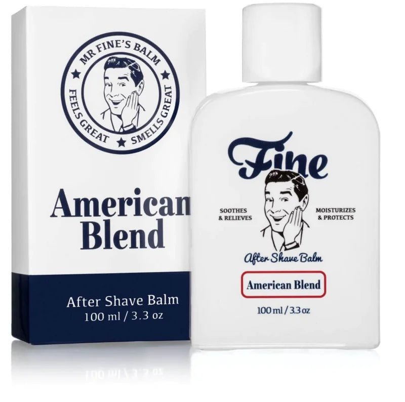 A white bottle and box of Fine Accoutrements American Blend Aftershave Balm, featuring vintage-style man’s art and text promoting its soothing, moisturizing, alcohol-free formula with a classic barbershop scent.