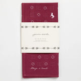 The Jenni Earle "Blaze A Trail" bandana is hand-dyed maroon with white geometric patterns, a small fox illustration, and the phrase "Blaze a Trail," wrapped in a branded paper label.
