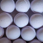 Rows of round, light purple Bath Bomb | French Lavender by Old Whaling Co., infused with epsom salt, are arranged in a grid pattern and viewed from above.