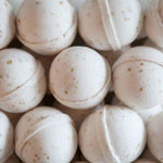 A close-up of Old Whaling Co. Bath Bombs in Oatmeal Milk + Honey, featuring small specks and arranged together for a soothing bath experience.