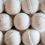 A close-up of Old Whaling Co. Bath Bombs in Oatmeal Milk + Honey, featuring small specks and arranged together for a soothing bath experience.