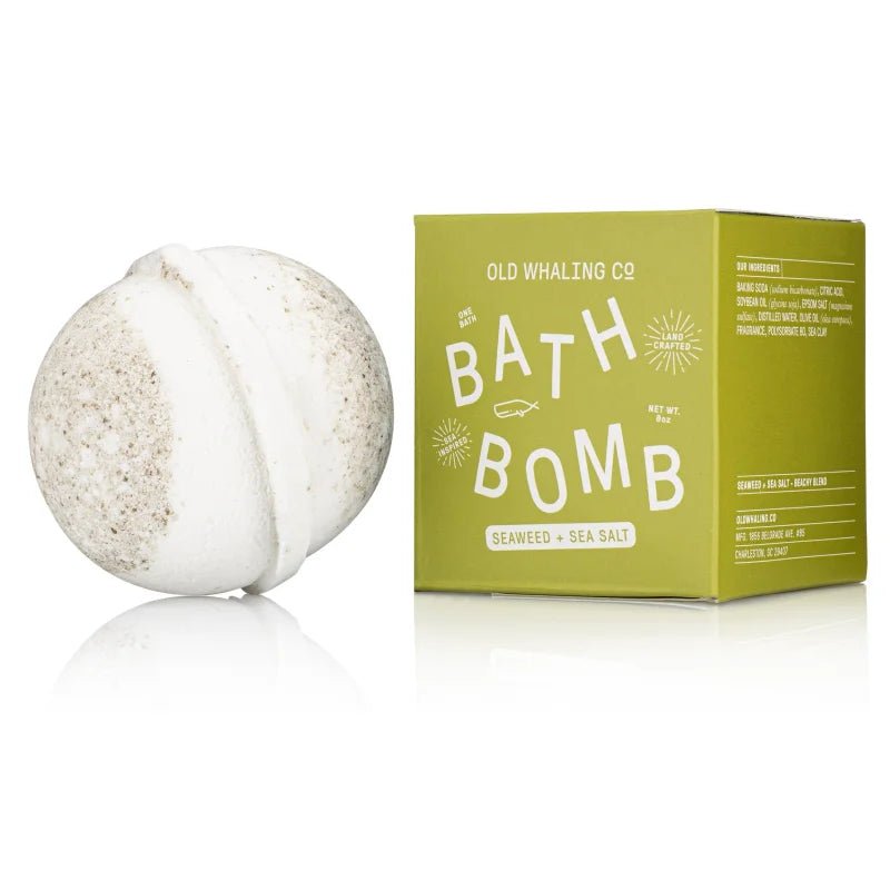 A white and beige bath bomb with sea clay rests beside a green box labeled "Bath Bomb | Seaweed & Sea Salt | Old Whaling Co.