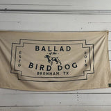 The Bird Dog Flag | Large by Ballad of the Bird Dog features a beige, neon-style design with black "Ballad of the Bird Dog, Brenham, TX, Estd 2018" text and a central dog illustration.