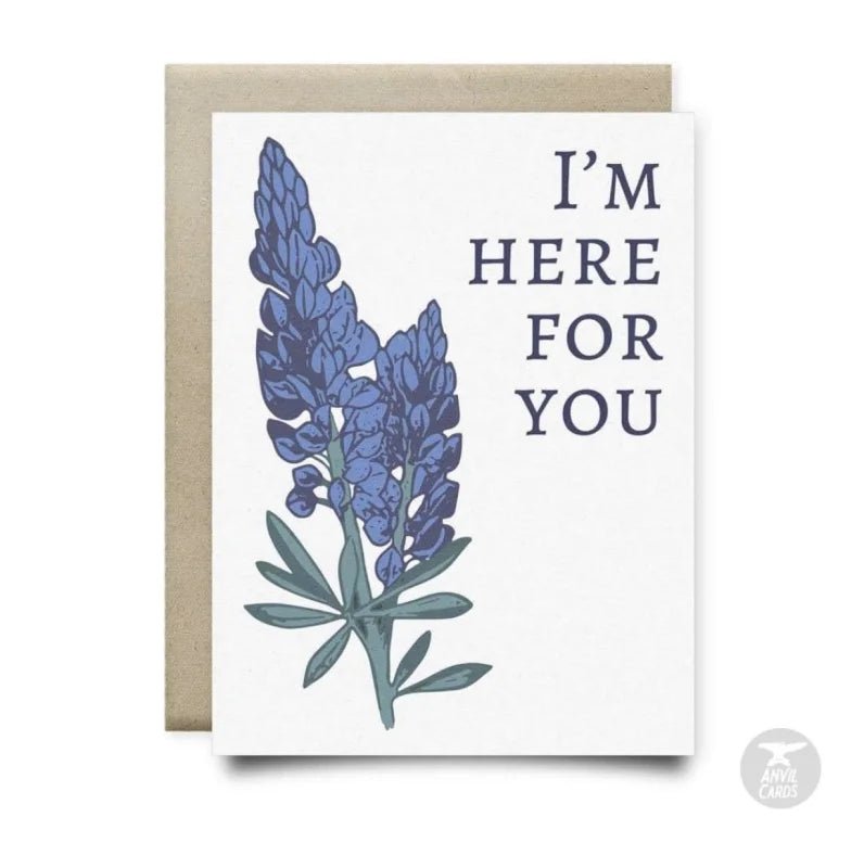 The Bluebonnets Here For You Card by Anvil Cards features blue lupine art and "I'M HERE FOR YOU" on the front, printed on linen paper. Blank inside for your message and includes a brown envelope.
