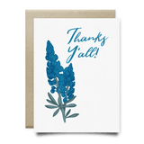 The Bluebonnets Thanks Yall Card by Anvil Cards features blue flowers and “Thanks Y’all!” on the front, printed on linen paper, includes a plain brown envelope, and is blank inside for your message.
