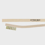 A brass cleaning brush with light bristles, an ergonomic handle, and "Otter Wax" branding is shown against a plain white background.