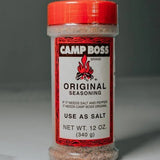 A 12 oz Camp Boss Seasoning container with a red lid includes label instructions to use this bold Texas blend as salt.