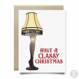 The Classy Christmas Leg Lamp Card by Anvil Cards features a lamp shaped like a woman's leg and "Have a Classy Christmas" in red. This A2 linen card comes with an envelope and is blank inside for your message.