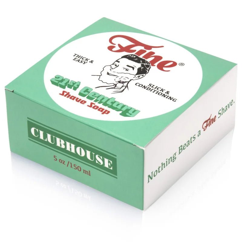 A green and white box of Fine Accoutrements Clubhouse 21C Shave Soap, tallow base, barbershop scent, 5 oz/150 ml, featuring branding and slogan on the packaging.