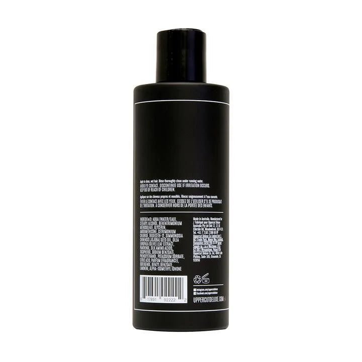 A black Everyday Conditioner | Uppercut Deluxe bottle for men, shown from the back, displays product details and ingredients like olive leaf extract in white text.