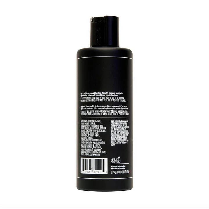 A black plastic bottle of Uppercut Deluxe Everyday Shampoo with a flip-top cap, shown from the back with white printed details—ideal for daily cleansing and prepping hair for styling. Brand: Uppercut Deluxe.