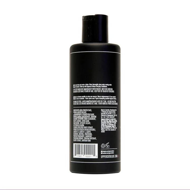 A black plastic bottle of Uppercut Deluxe Everyday Shampoo shown from the back, with white product info text and a barcode—perfect addition to men's hair care routines and styling essentials.
