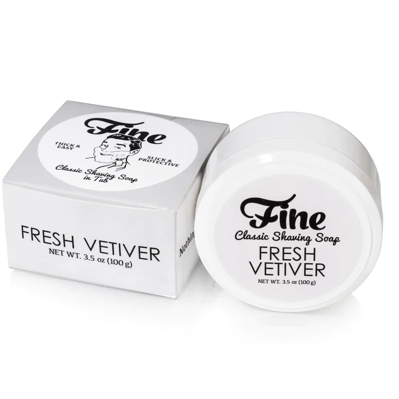 A tub and box of Fine Accoutrements Fresh Vetiver Classic Shaving Soap in tub, tallow-based for a classic barbershop shave, each labeled with product name and net weight (3.5 oz/100 g), displayed on a white background.