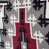 A close-up of the Ganado Rug Classic "Snowflake" CA 1980 by Vintage, featuring geometric patterns in red, black, white, and gray that showcase classic Ganado Navajo weaving style.