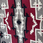 The Vintage Ganado Rug Classic "Snowflake" CA 1980 features authentic woven textile with geometric patterns in red, gray, black, and white, showcasing symmetrical shapes and zigzag lines in a distinctive Navajo style.