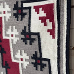 A close-up of the Vintage Ganado Rug Classic "Snowflake" CA 1980 shows authentic Navajo weaving with geometric patterns in black, white, gray, and red, sharp angular designs, and a thick black border in the classic Ganado style.