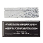The Mollyjogger Ironquill Hook & Knife Sharpening Stone is made in the USA from soft Arkansas Novaculite, features a product label detailing its origin and high-purity silica content, and is perfect for sharpening fishing hooks.