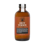A brown glass bottle of "Hot Toddy Syrup" by Yes Cocktail Co. features honey, lemon, and warm spice—ideal for making a cozy hot toddy or as a delicious honey lemon cocktail mixer.