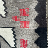 Close-up of a Klagetoh Rug Circa 1950 by Vintage, showcasing geometric black, white, and gray patterns with four small red rectangles near the center.