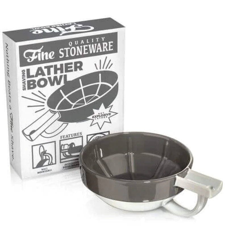 A gray and white Fine Accoutrements Lather Bowl with handle is displayed before its box labeled "Fine Quality Stoneware Shaving Lather Bowl," ideal for use with your favorite shaving brush and traditional shaving soap.