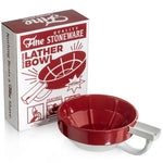 The red and white Fine Accoutrements Lather Bowl sits next to its packaging, which features the product name, highlights its use with a shaving brush and traditional shaving soap, and displays an illustration of the bowl.