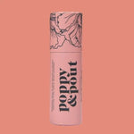 A handmade Lip Balm | Poppy & Pout by Poppy & Pout in a pink cylindrical container with a floral lid design and “poppy & pout” printed vertically, shown against a solid pink background.