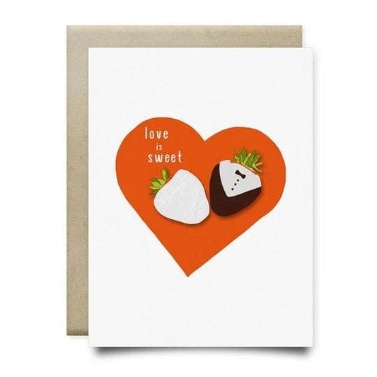 The Love is Sweet Card by Anvil Cards features a large red heart, two chocolate-covered strawberries, and "love is sweet" on linen A2 paper. Blank inside and includes a brown envelope.