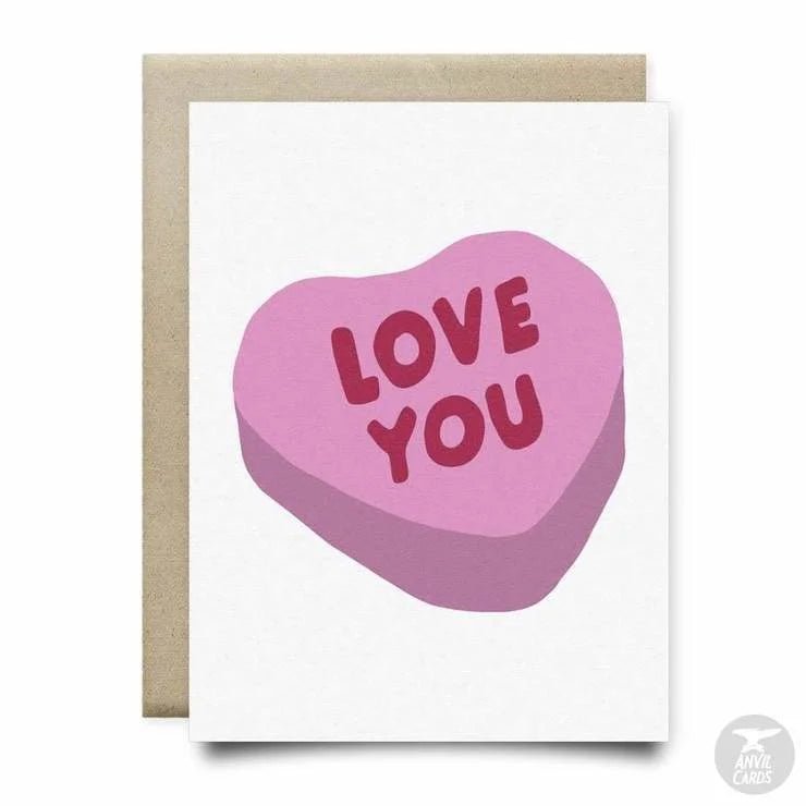 The Love You Candy Heart Card by Anvil Cards features a pink heart candy with "LOVE YOU" on linen paper, comes with an envelope, and is blank inside for your message.