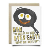 Anvil Cards’ “Mom Makes It Over Easy” is an A2 linen greeting card featuring a happy frying pan illustration and the text: "Mom, you make it all seem over easy! Happy Mother's Day!" Card is blank inside for your message.