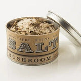 An open tin of Beautiful Briny Sea’s Mushroom Sea Salt reveals coarse salt blended with dried mushrooms—ideal for bringing rich, umami flavor to your favorite dishes.